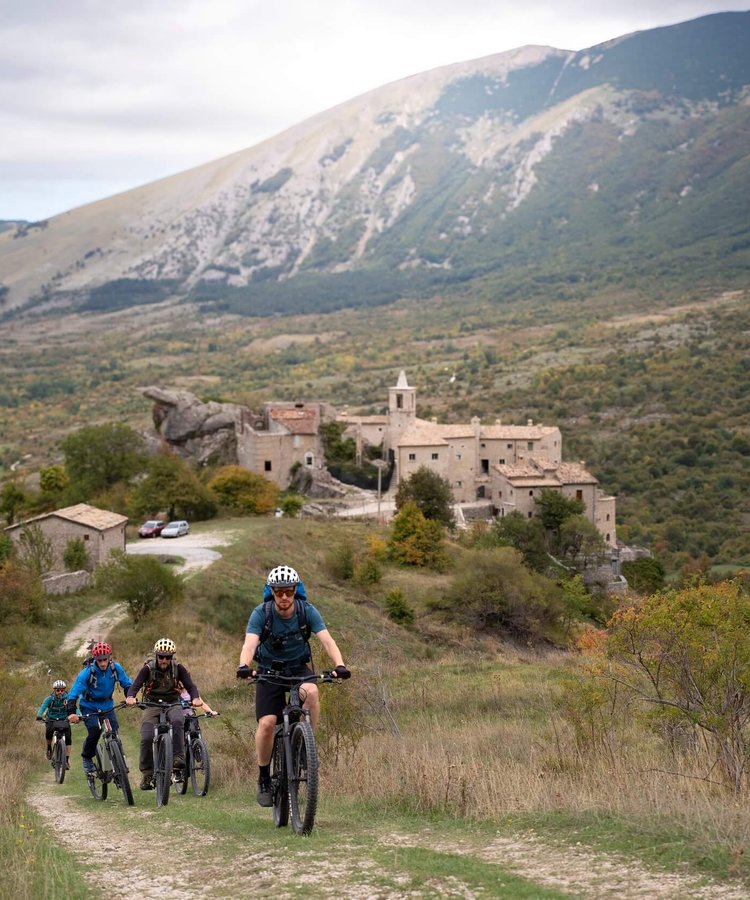 A-group-of-Slow-Cyclists-riding-in-Abruzzo-outside-a-mountain-village