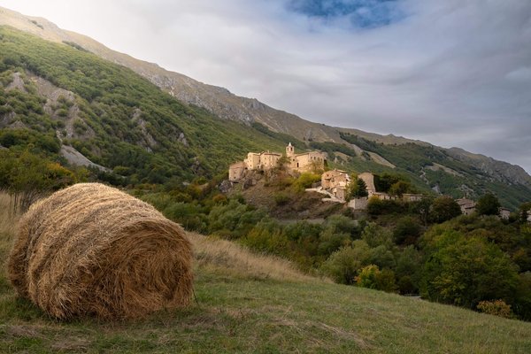 A-hay-bale-and-mountain-village-seen-on-a-Slow-Cyclist-journey-in-Abruzzo